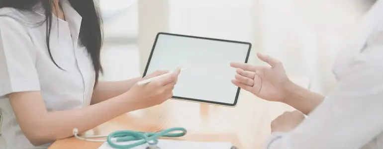 Zwei Menschen überreichen einen Tablet im Life Science Bereich